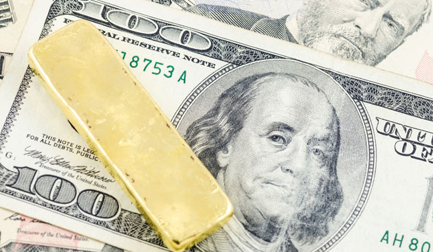 Gold bar and dollars