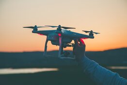 Drone being held against sunset Drone being held against sunset
